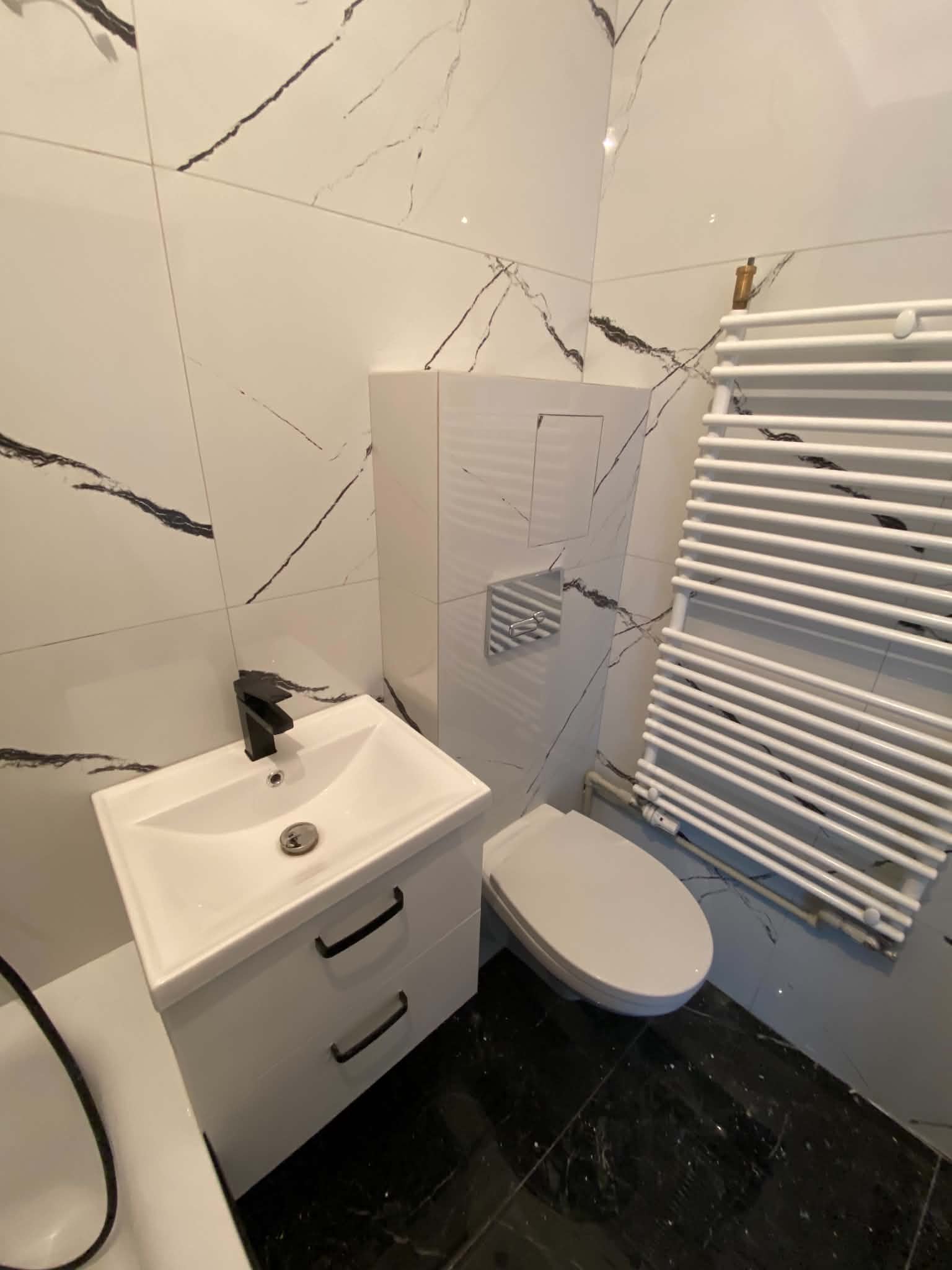 Wall-hung vanity and toilet against large-format marble-look wall tile